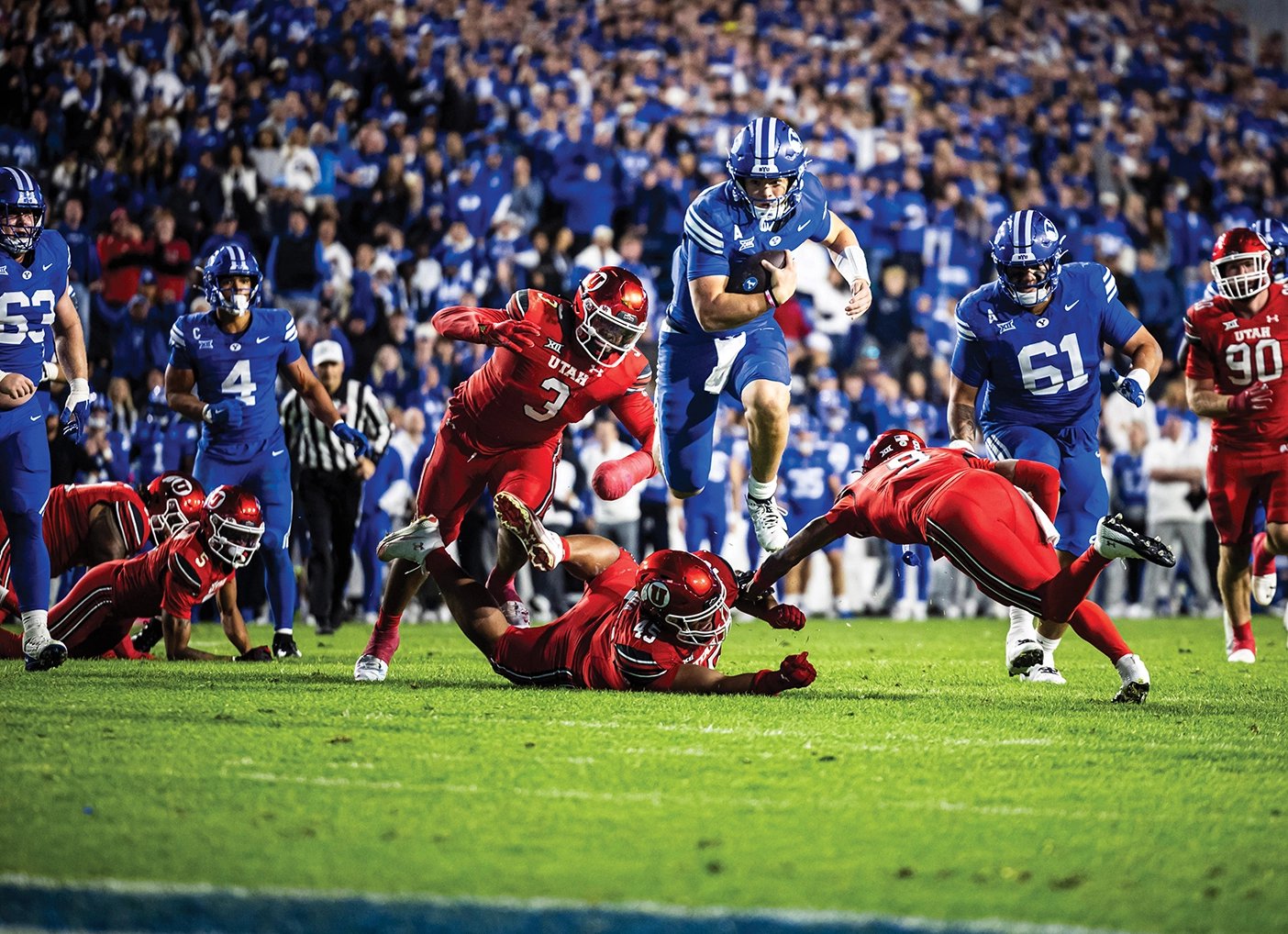 BYU quarterback Bear Bachmeier hurdles a Utah defender on a run at LaVell Edwards Stadium